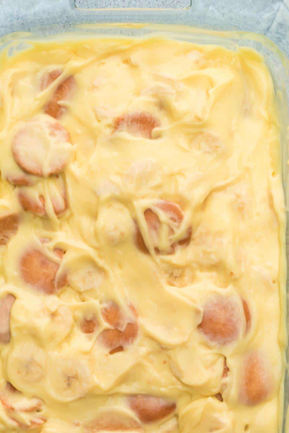 Close-up of a creamy yellow mixture with sliced bananas.