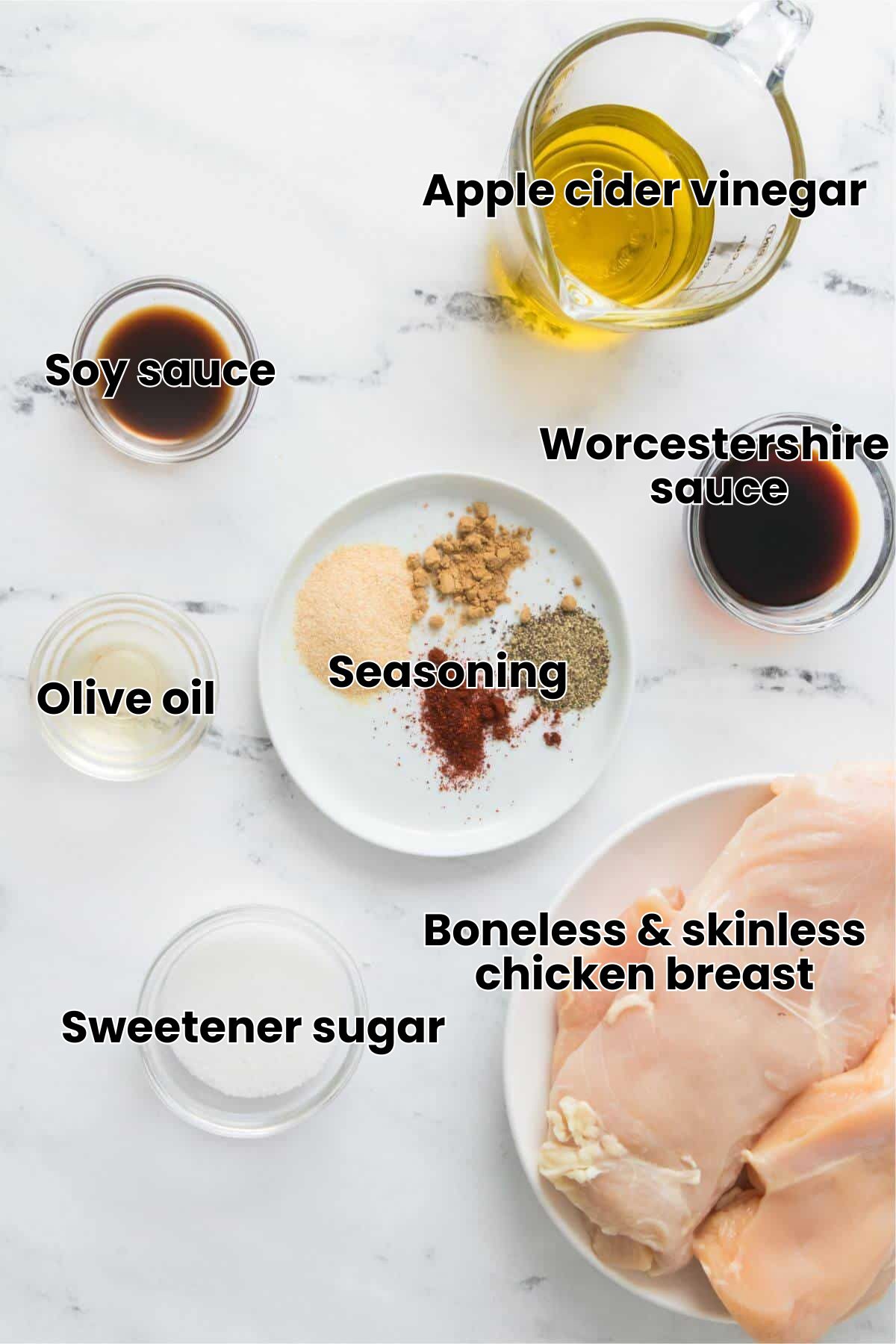 Raw chicken breasts with olive oil, soy sauce, vinegar, sugar, and a plate of spices on a marble surface.