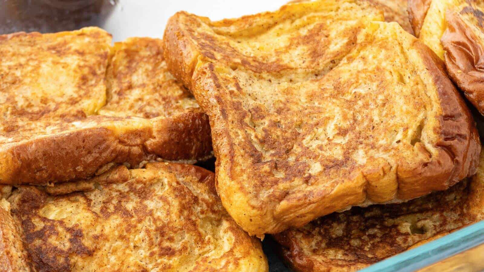 Golden brown French toast slices stacked in a dish.