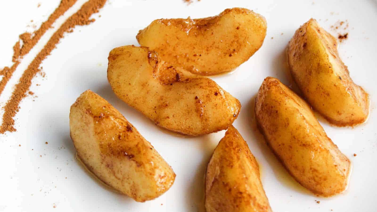 Cinnamon apple slices on a white plate.