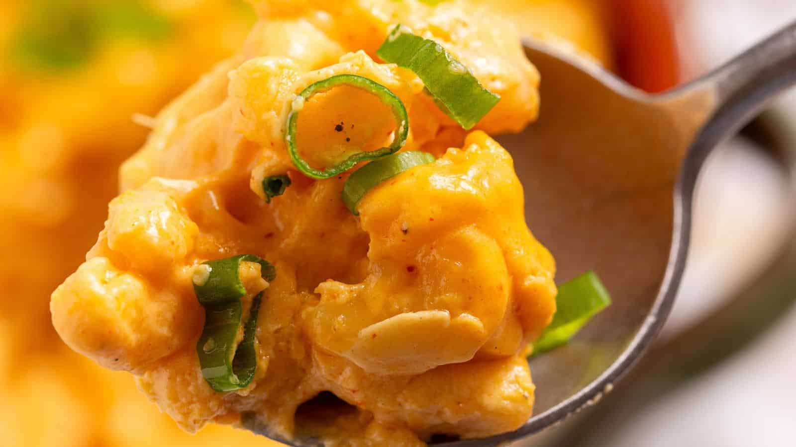 A bowl of macaroni and cheese in front of a slow cooker.
