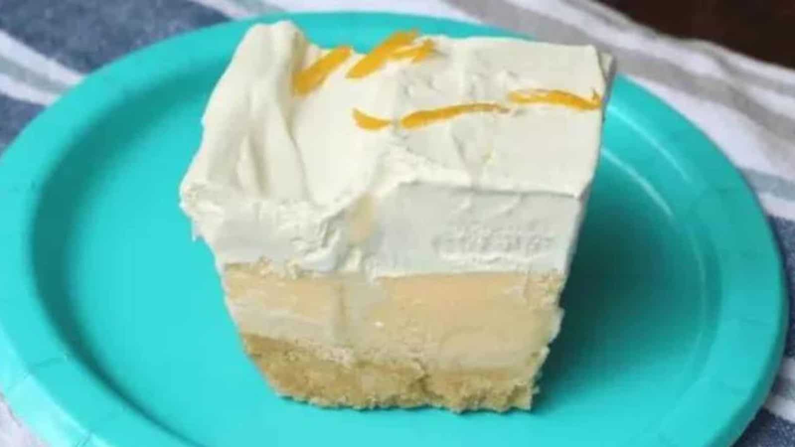 A piece of cake on a teal plate on a wooden background.