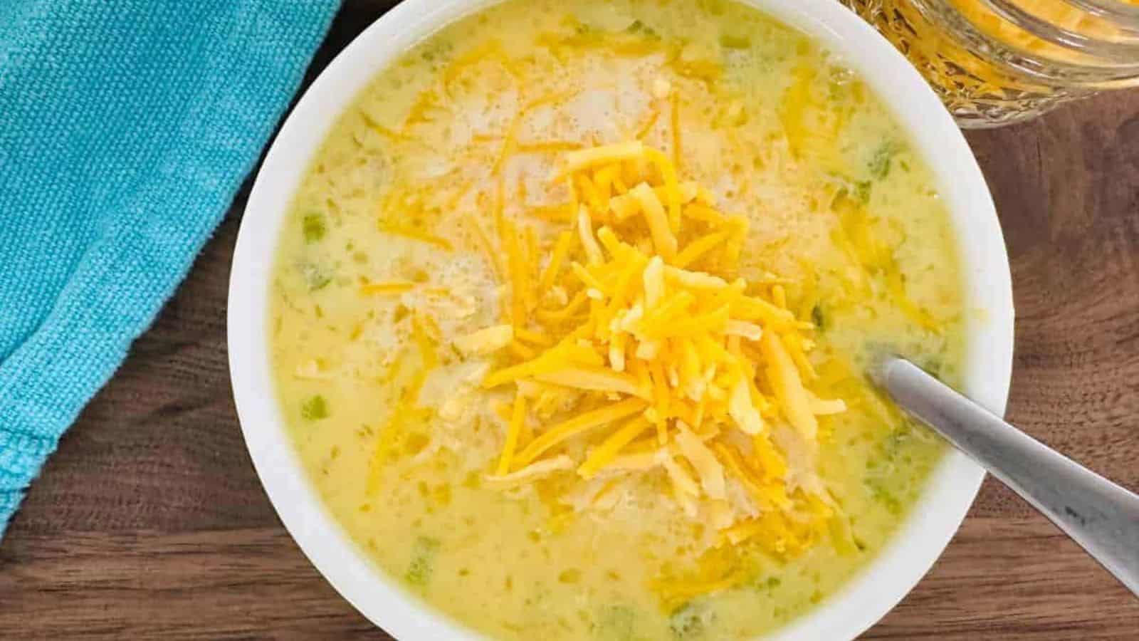 A bowl of soup with cheese and green peppers.