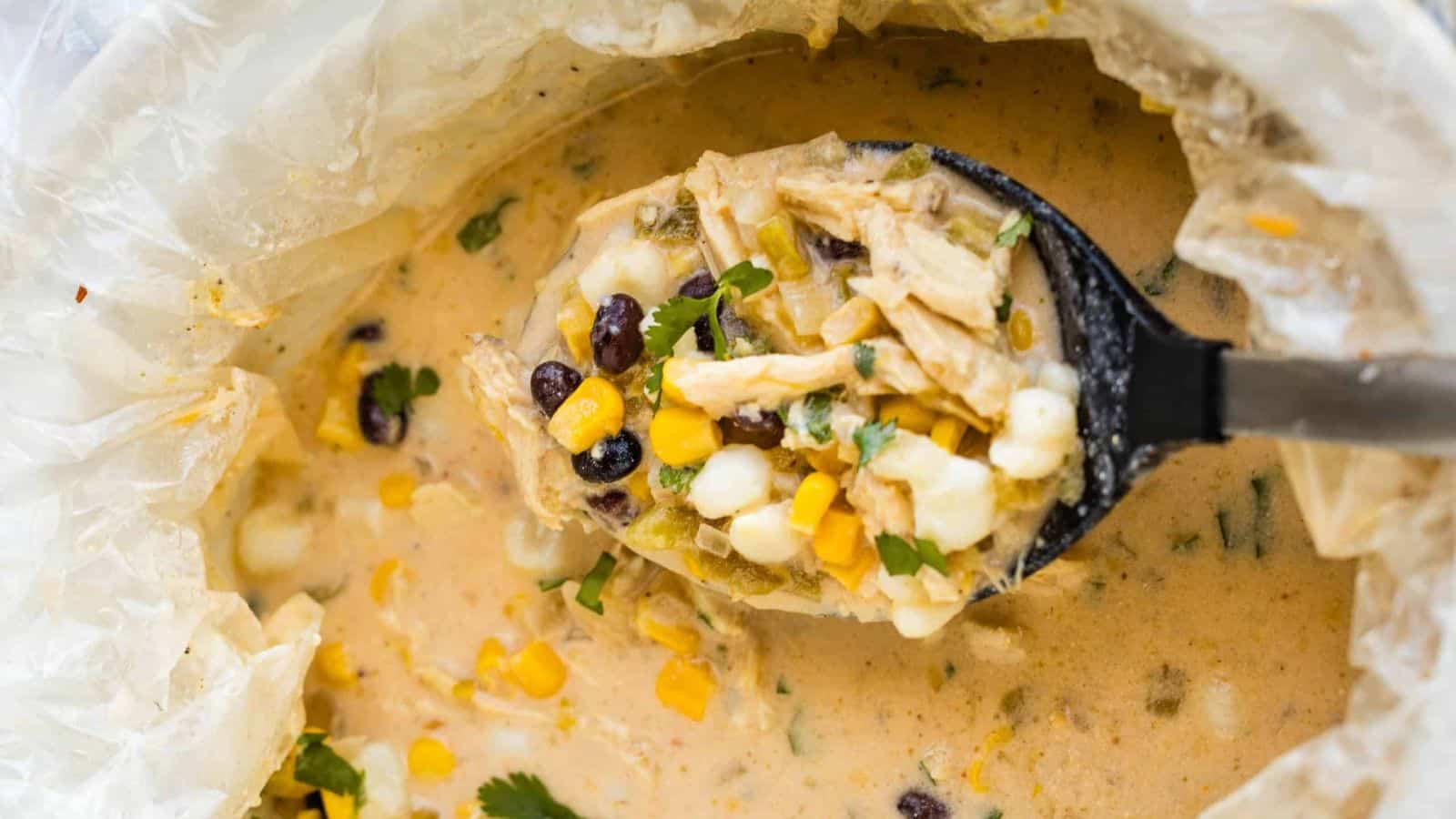 A bowl of mexican chicken chowder with corn and black beans.
