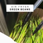 Green beans in the air fryer being tossed with text on th eimage.