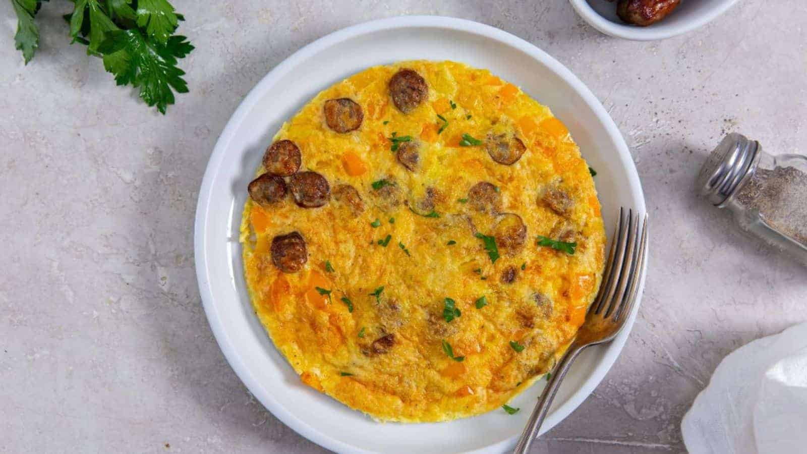 Air Fryer Omlette with bell peppers, parsley, cheese, and sausage on a white plate with a fork.