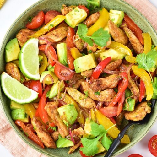 Chicken fajita salad with bell peppers and avocados in a bowl.