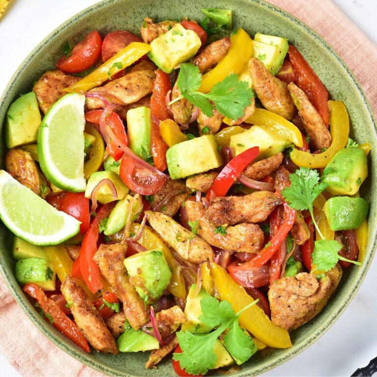 Chicken fajita salad with bell peppers and avocados in a bowl.