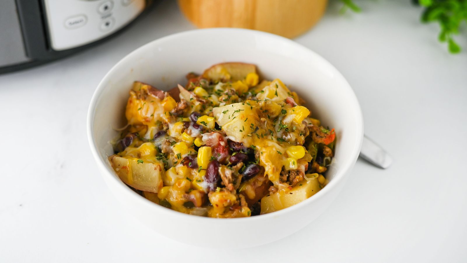 Cowboy casserole with ground beef in a white bowl.