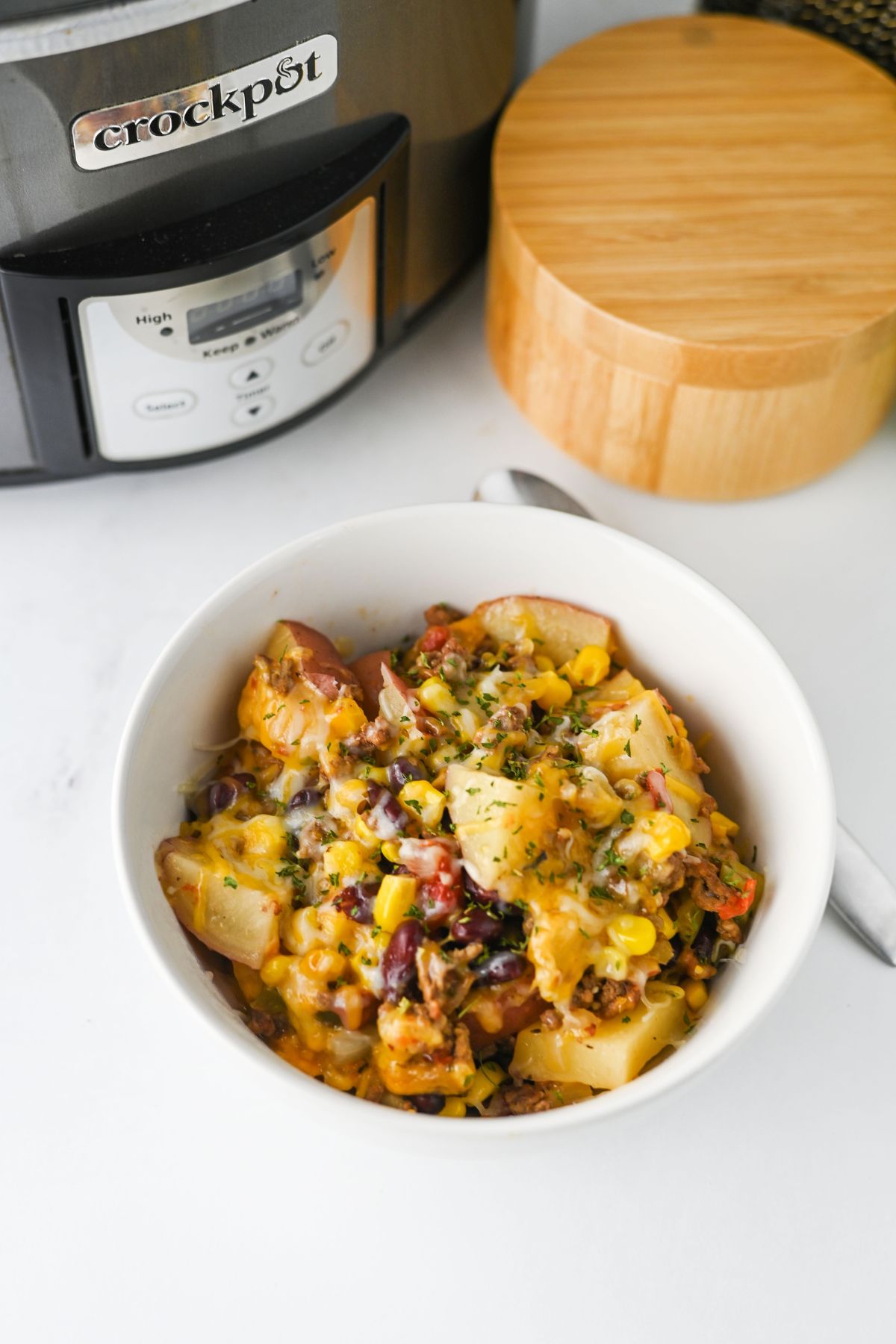 Cowboy casserole with ground beef in a white bowl.