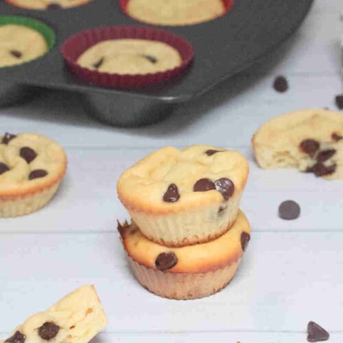 Two yogurt chocolate chip muffins stacked with more around them.