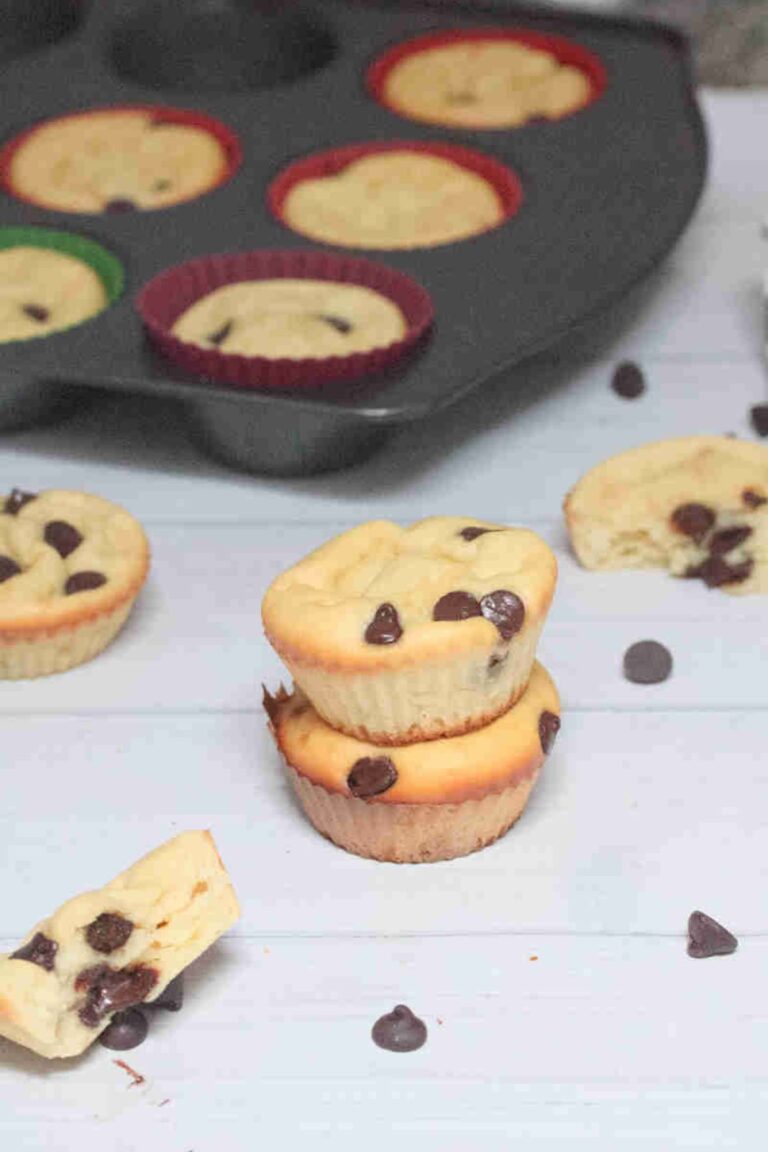 Two yogurt chocolate chip muffins stacked with more around them.