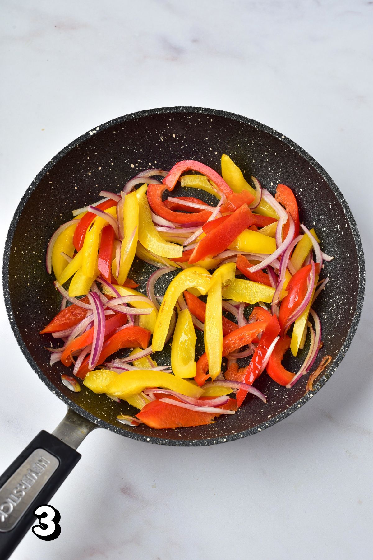 Bell peppers and onions in a skillet.