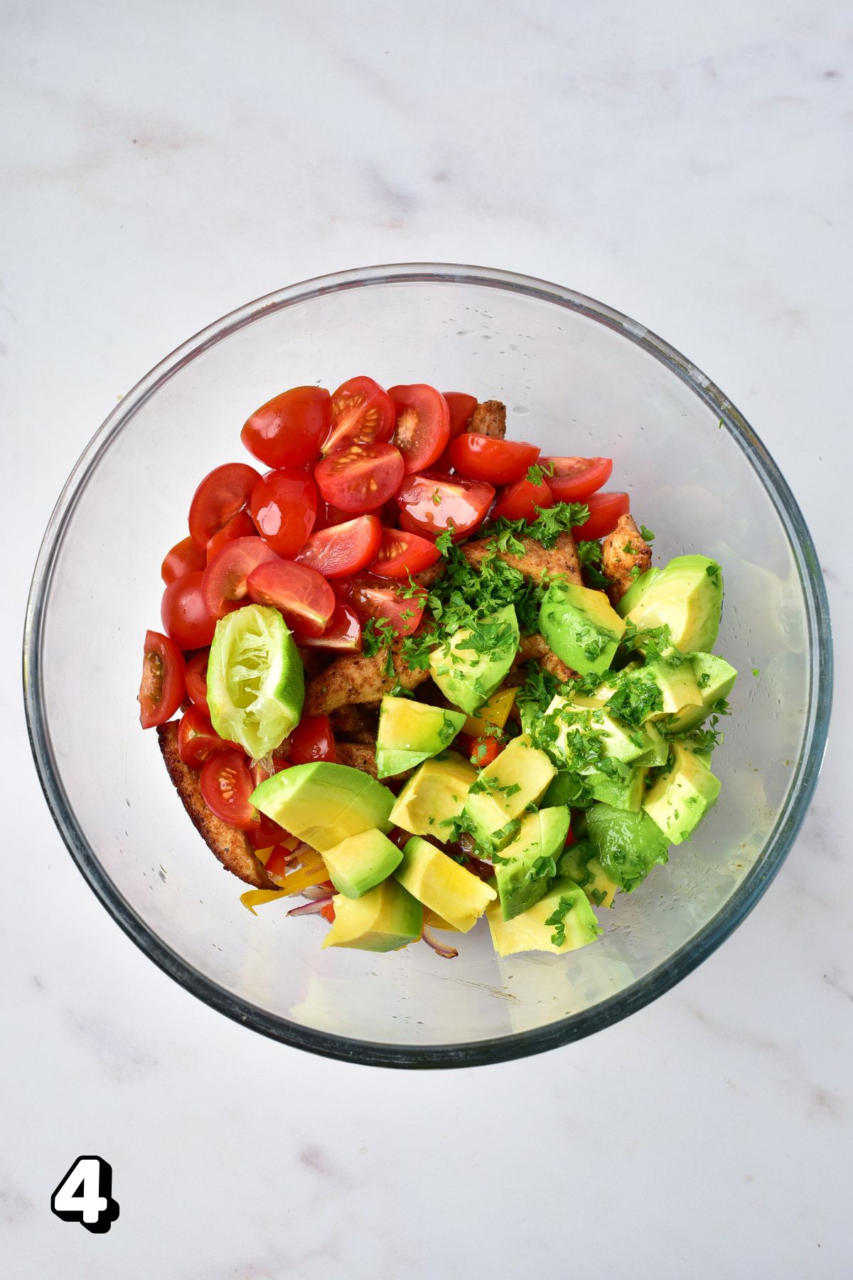 Avocados, tomatoes, and cooked chicken in a bowl.