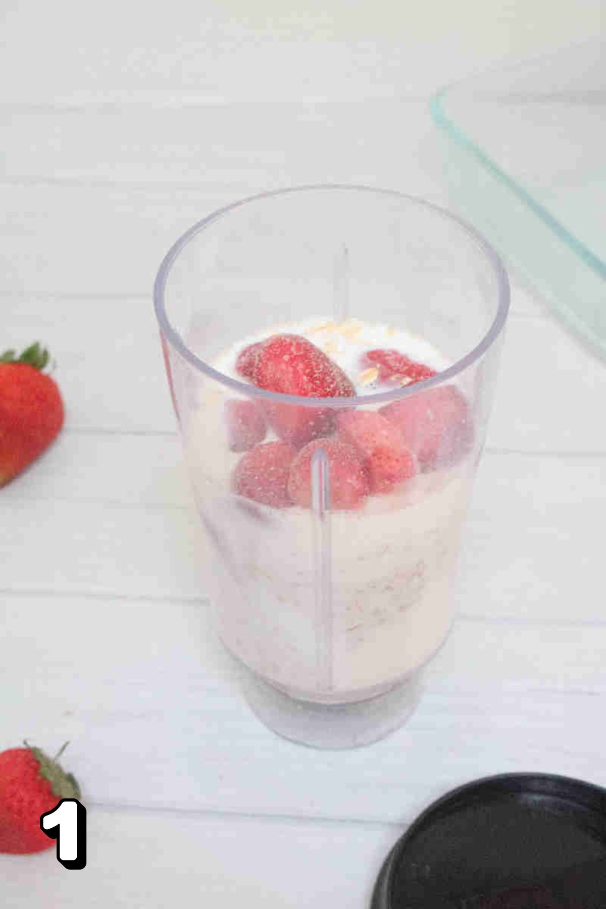 A blender of strawberries, oats, yogurt, and milk.