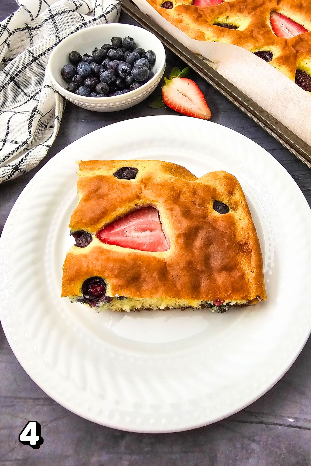 A Square of berry pancakes on a white plate.
