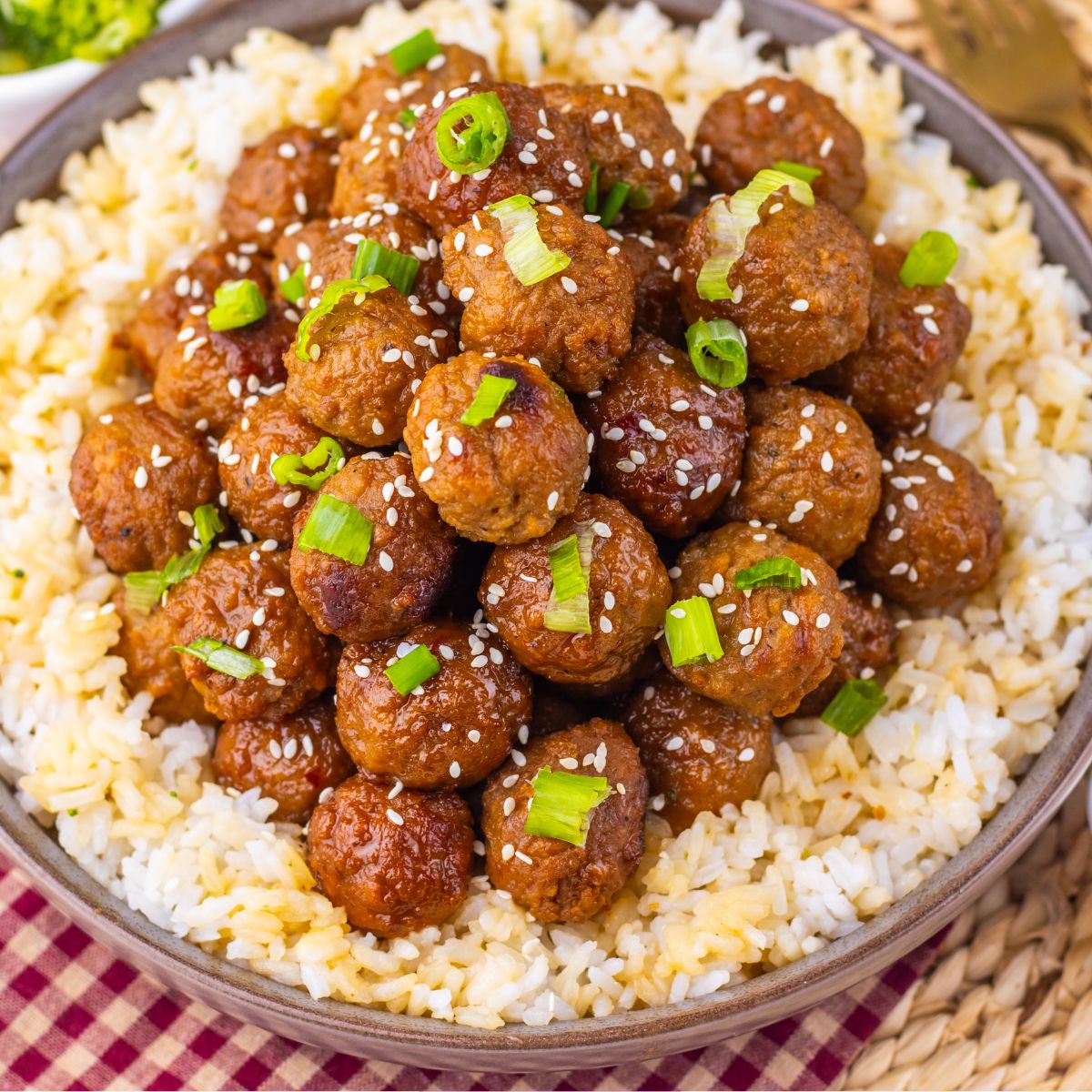 Mongolian meatballs with green onions on them over rice.