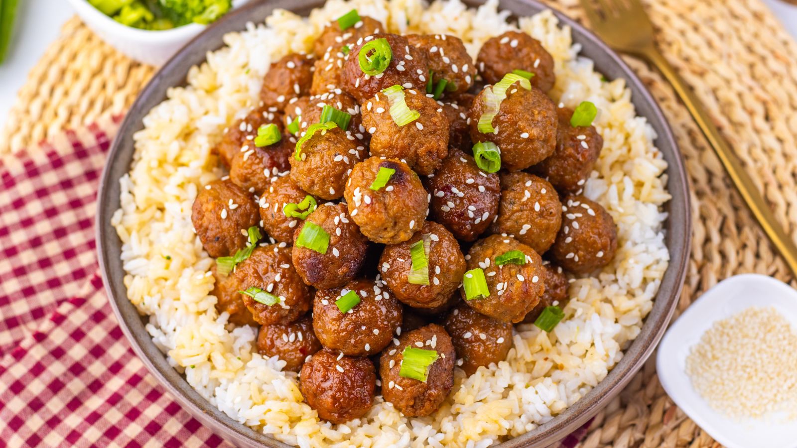 Mongolian meatballs with green onions on them over rice.