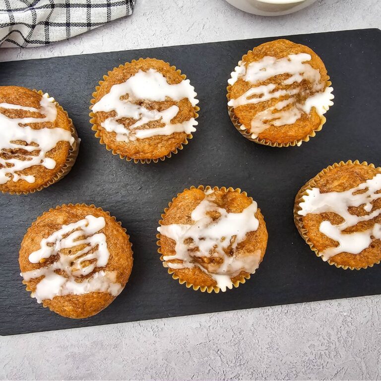 Apple pie muffins with cake mix lined up on a black cutting board.
