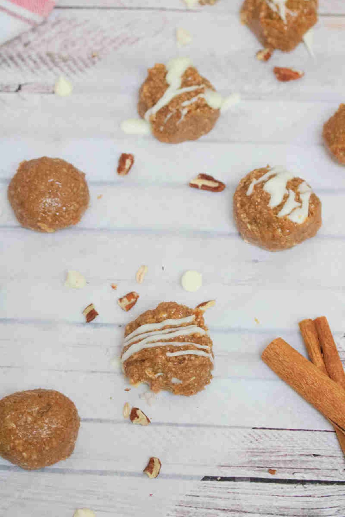 No bake cinnamon roll balls with white chocolate on top on parchment paper.