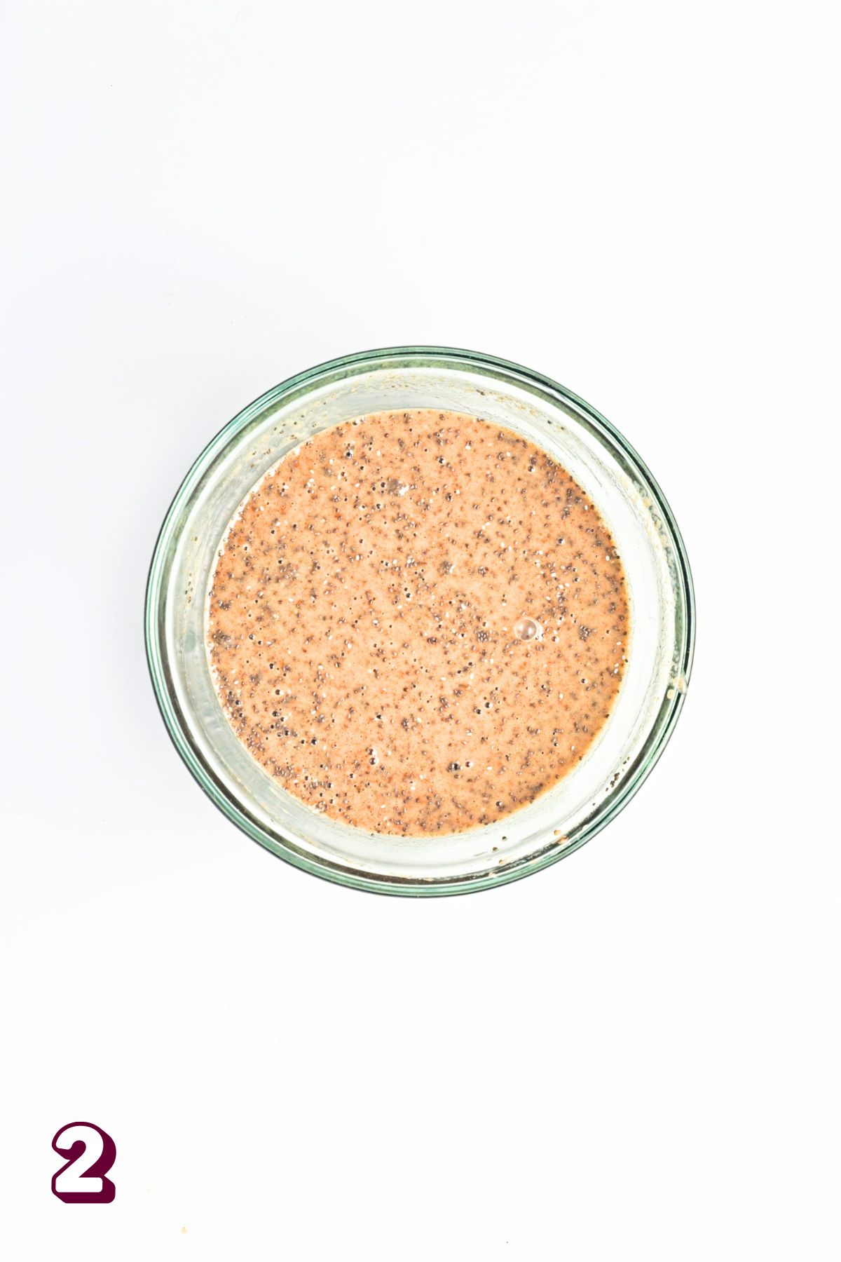 Glass bowl with maple syrup and milk and chia seeds.