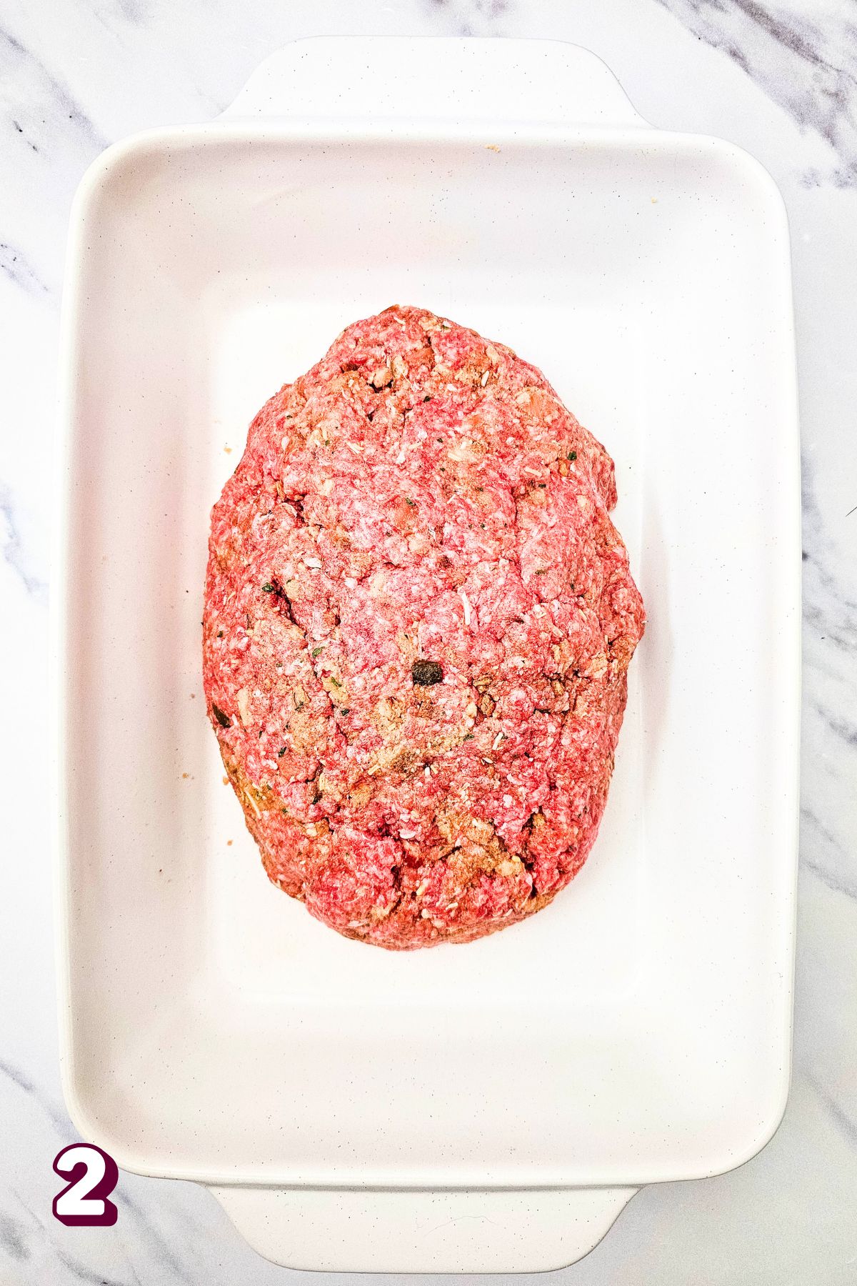 Raw salsa meatloaf in an oval shape in a baking dish.