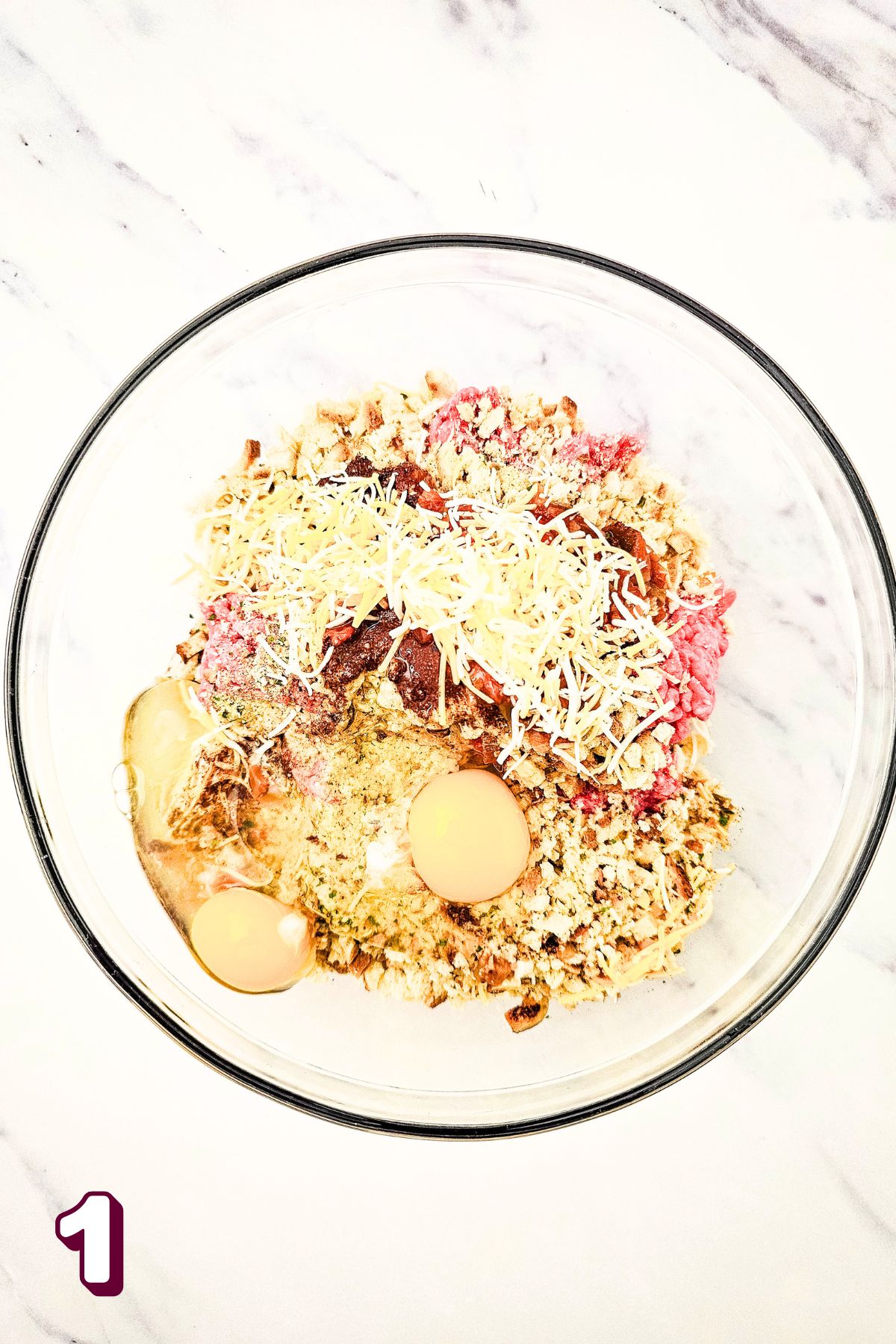 Mixing bowl with raw beef, egg, stuffing mix, and cheese.
