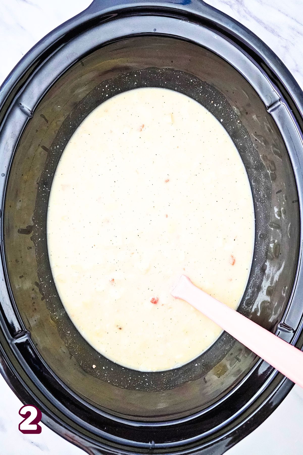 A crockpot with loaded potato soup in it and a ladle.