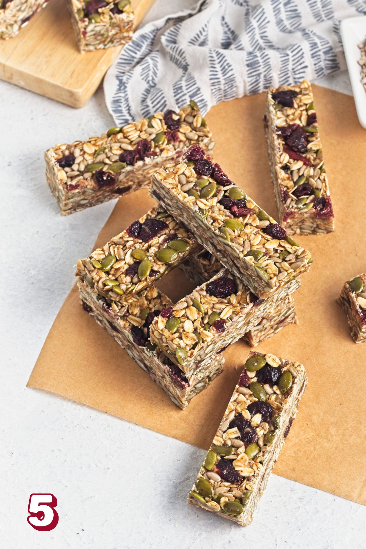 No bake granola bars stacked on parchment paper.