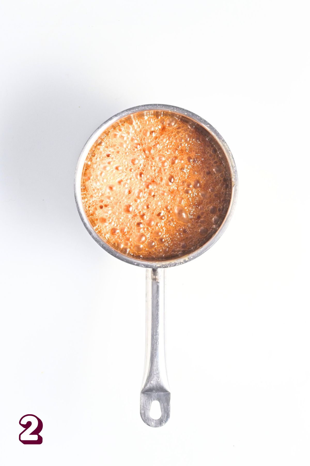 Small pot with honey bubbling in it.