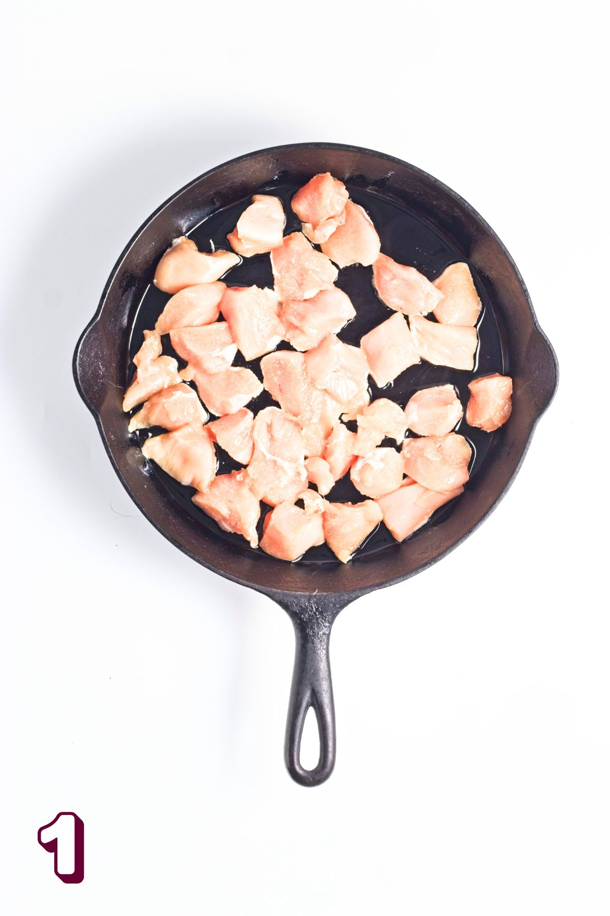 Raw chicken in a cast iron pan.