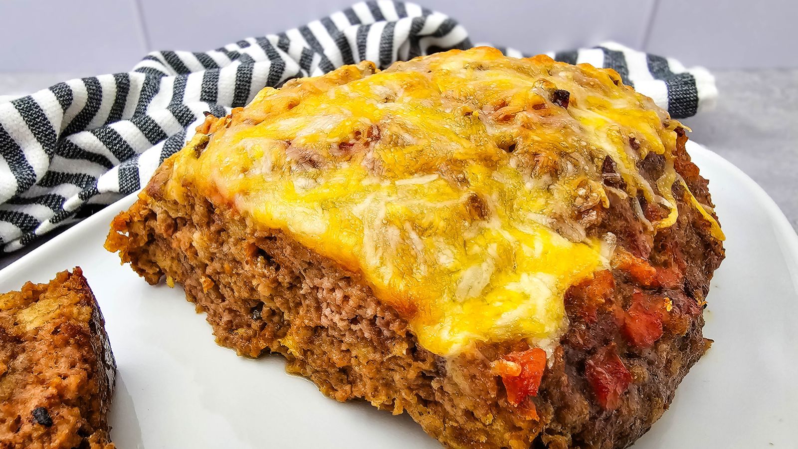 Cheesy salsa meatloaf cut in half on a plate.