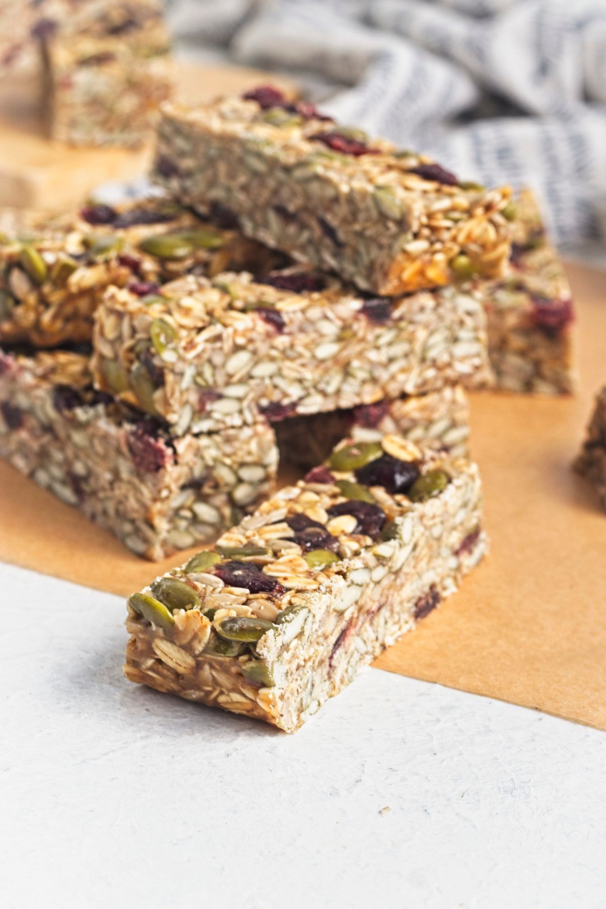 No bake granola bars stacked on parchment paper.