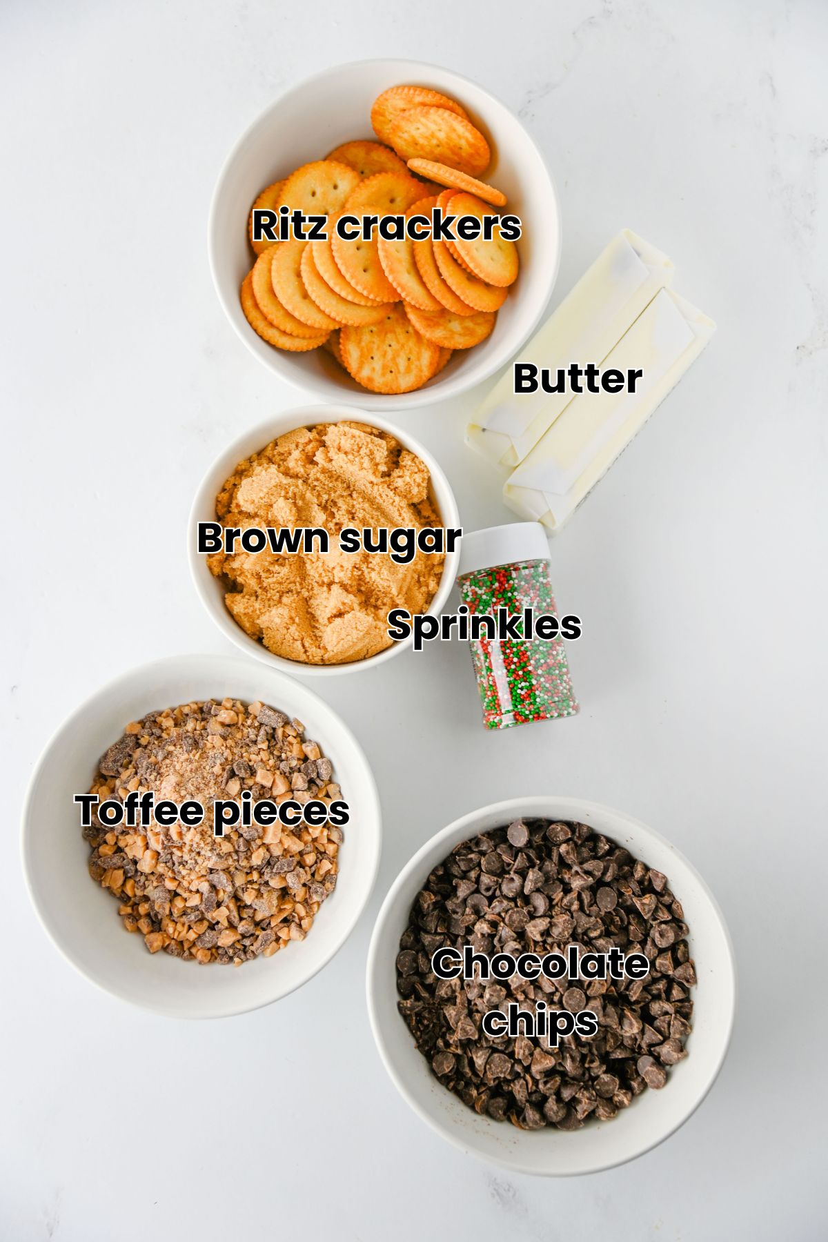 Ritz crackers, chocolate chips, butter, sugar, sprinkles, and toffee all with text ;abels over top.